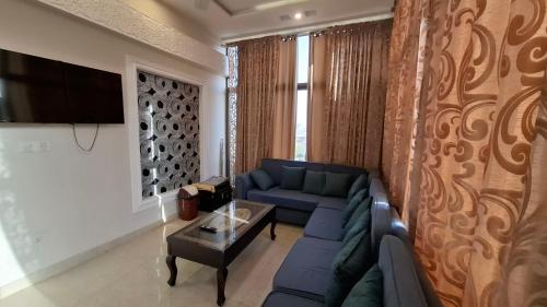 a living room with a blue couch and a table at Hill View Park Guest House Citihousing jhelum satellite town in Jhelum