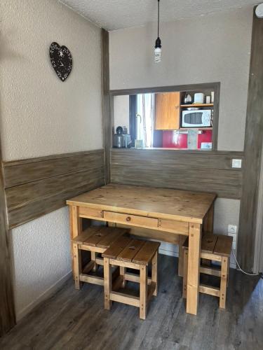 une table et un banc en bois dans une cuisine avec un comptoir dans l'établissement Cham sud, à Chamonix-Mont-Blanc