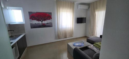 sala de estar con sofá y árbol rojo en Villa Grafenberg Ulcinj, en Ulcinj