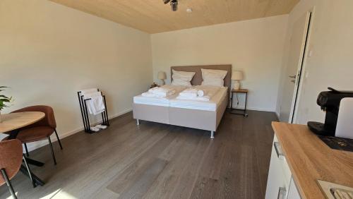 a bedroom with a white bed and a wooden floor at Quiet Room with Balcony in Peißenberg
