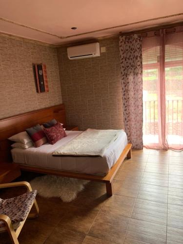 Un dormitorio con una cama en una habitación con ventana. en Apartamento rural FRAGARIA, en Casas del Monte