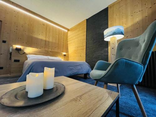 a hotel room with a bed and a table and a chair at Hotel le Sacca, nouvelle équipe in Cauterets
