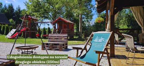 un parque con un patio de juegos con un columpio y un banco en Apartament Komarno III, en Jelenia Góra