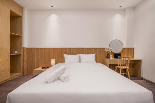 a bedroom with a large white bed and a desk at Aurora Villa - Near My Khe Beach & City Center by The Key in Da Nang