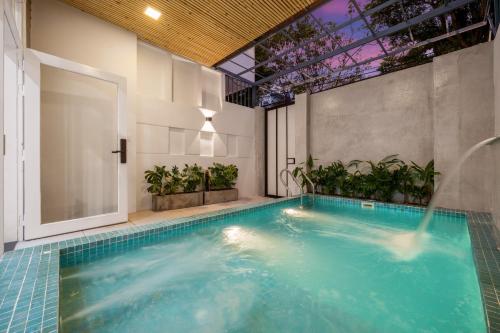 a swimming pool in a building with an indoor swimming poolvisor at Aurora Villa - Near My Khe Beach & City Center by The Key in Da Nang