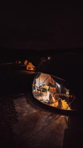 a tent with a table in it at night at Tatra Glamp Okrzeszyn - Siec noclegowa Tatra Glamp in Okrzeszyn