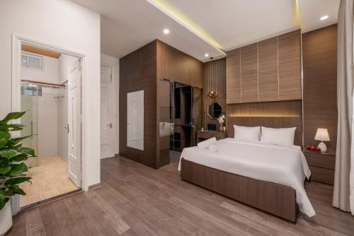 a bedroom with a large white bed and a bathroom at Aurora Villa - Near My Khe Beach & City Center by The Key in Da Nang