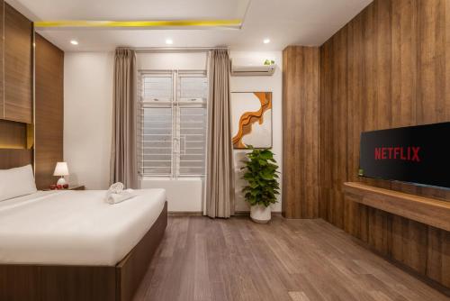 a hotel room with a bed and a tv at Aurora Villa - Near My Khe Beach & City Center by The Key in Da Nang