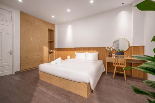 a bedroom with a large white bed and a desk at Aurora Villa - Near My Khe Beach & City Center by The Key in Da Nang