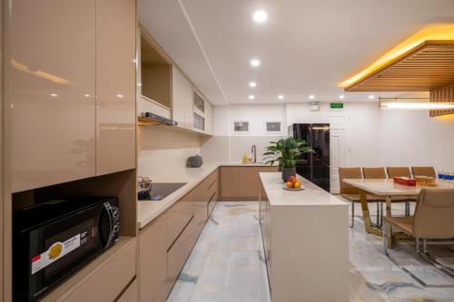 a kitchen and dining room with a dining table at Aurora Villa - Near My Khe Beach & City Center by The Key in Da Nang