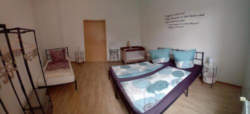 a room with two beds and a chair in it at Erzgebirge in Schneeberg