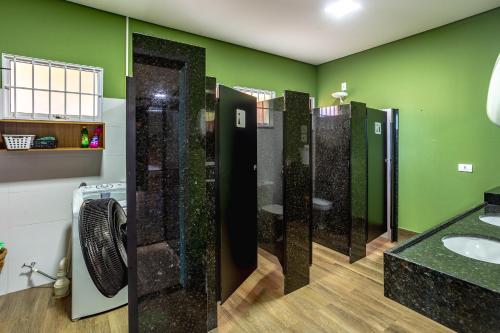 a bathroom with green walls and a row of sinks at RESORT PARTICULAR perfeito p/ famílias com crianças e grupos in Foz do Iguaçu