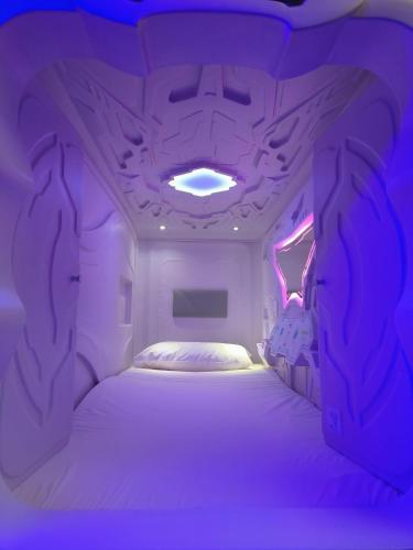 a purple room with a large bed in it at CAPSULE INN VALENCIA Hostel in Valencia