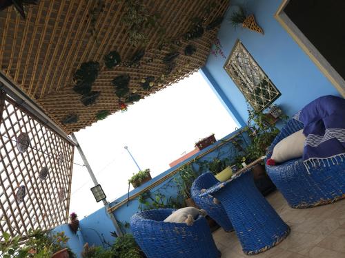 a balcony with blue wicker chairs and plants at Appartement avec Terrasse in Larache