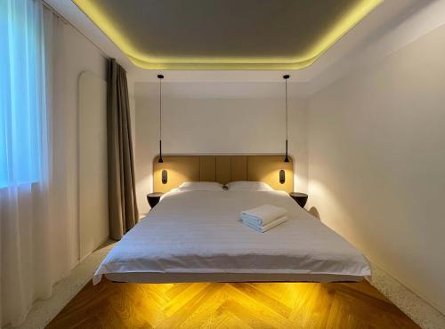 a bedroom with a white bed with two towels on it at NUC living - Apartment 01 in Suceava