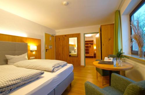 1 dormitorio con 2 camas, mesa y mesa en Hotel Waldmann, en Schwangau