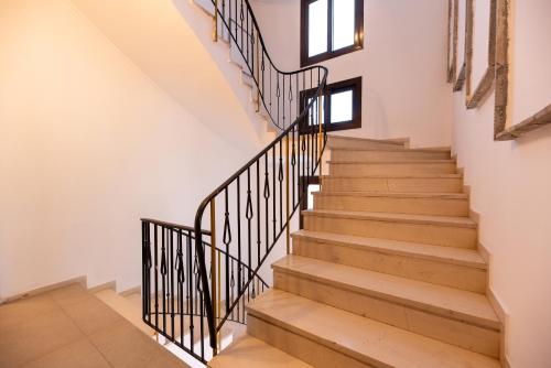 a staircase in a house with wooden floors and black railings at Stone Palace Hotel Near Athen's Airport Free Shuttle From and to Athen's Airport in Spáta