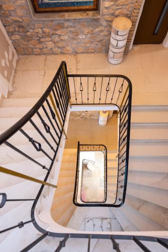a spiral staircase in a building with a bench at Stone Palace Hotel Near Athen's Airport Free Shuttle From and to Athen's Airport in Spáta