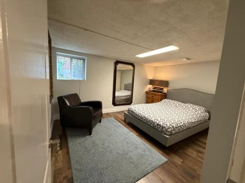 una camera da letto con un letto, una sedia e uno specchio di NORTH TORONTO - 2 Bdrm With WiFi and Parking near Yonge St a Toronto