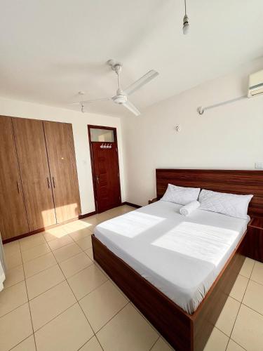 a bedroom with a large bed with white sheets at Seville Stays Cozy Getaway in Mombasa