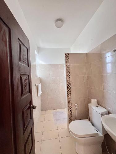 a bathroom with a toilet and a sink at Seville Stays Cozy Getaway in Mombasa