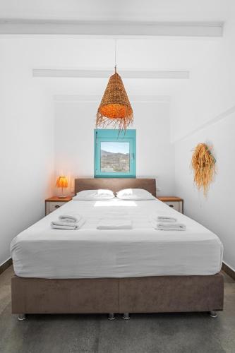 a bedroom with a large white bed with a blue frame at Notte di Mare in Kardiani