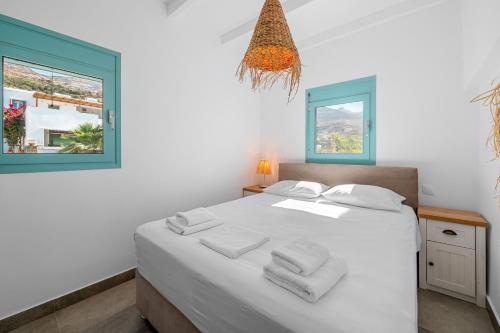 a bedroom with a white bed with towels on it at Notte di Mare in Kardiani