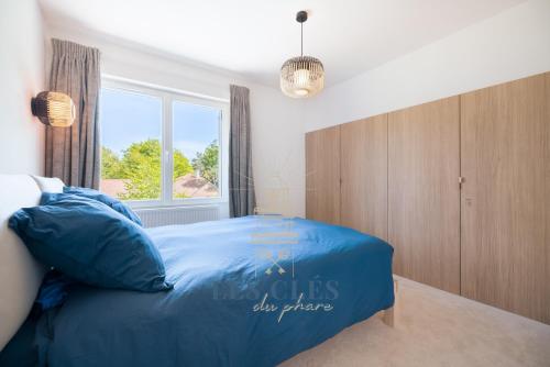 a bedroom with a large blue bed with a window at Villa Los Cuatro, situé au cœur du Touquet in Le Touquet-Paris-Plage