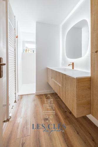 une salle de bain avec un lavabo et un miroir dans l'établissement Villa Los Cuatro, situé au cœur du Touquet, à Le Touquet-Paris-Plage