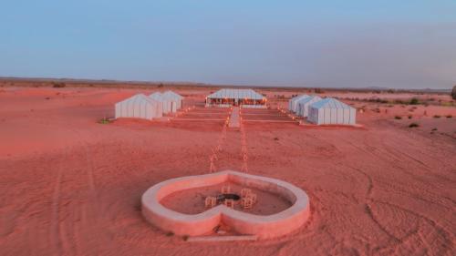 a group of buildings in the middle of a desert at Sultan's Sinbad Luxury Camp in Merzouga