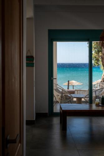 a room with a door open to a balcony with the ocean at Notte di Mare in Kardiani