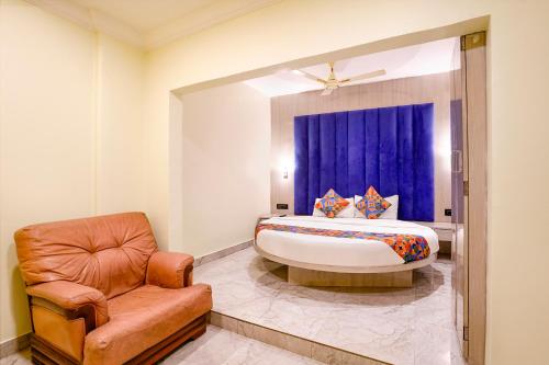 a bedroom with a king sized bed and a chair at Glitz Hotels Priceless-Lokhandwala in Mumbai