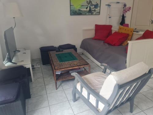 - un salon avec un lit, une table et une chaise dans l'établissement Petite maison du samedi au samedi, à Biscarrosse