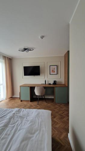 a bedroom with a bed and a desk with a television at Fuego in Rowy