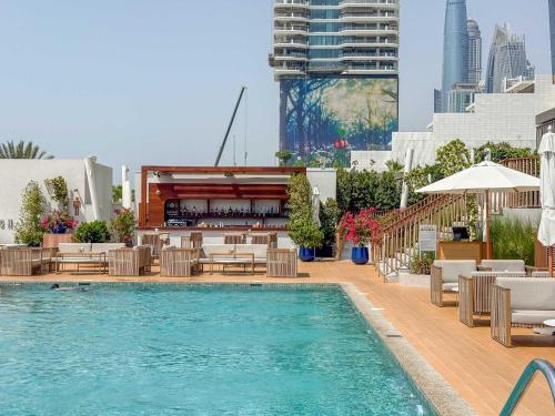 a swimming pool with chairs and a bar on a building at Jumeirah Beach Residences Private Beach & Sea View in Dubai
