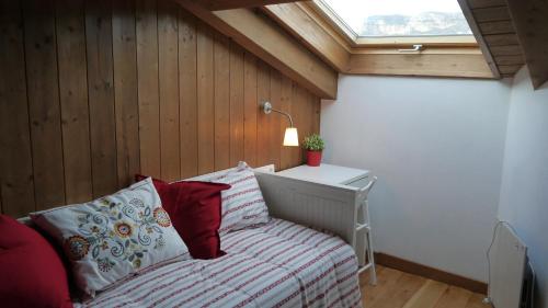um quarto com uma cama com um candeeiro e uma janela em Coqueto Apartamento Dúplex en Roda de Isábena em Roda de Isábena