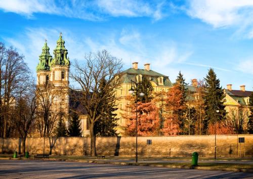 a large building with a clock tower on top of it at Tatra Glamp Okrzeszyn - Siec noclegowa Tatra Glamp in Okrzeszyn
