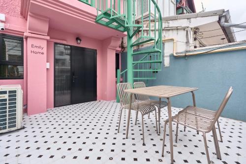 a table and two chairs sitting on a patio at Emily Home-Charming 3BR in Chiang Mai Old Town, Steps from Wat Phra Singh & Sunday Walking Street by Beginning With in Chiang Mai