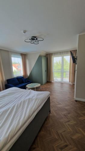 a bedroom with a bed and a couch and windows at Fuego in Rowy