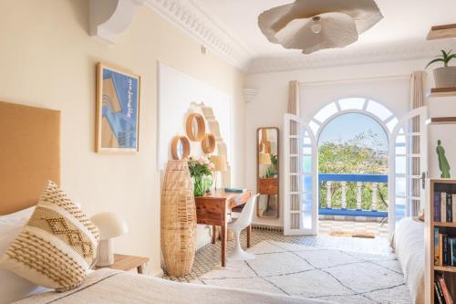 a bedroom with a bed and a desk and a table at Villa Beldi in Essaouira