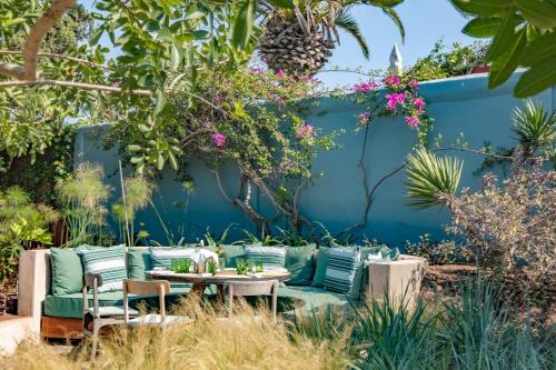 a garden with a couch and tables and flowers at Villa Beldi in Essaouira