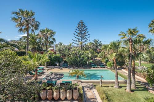 an aerial view of a resort pool with palm trees at Villa Beldi in Essaouira