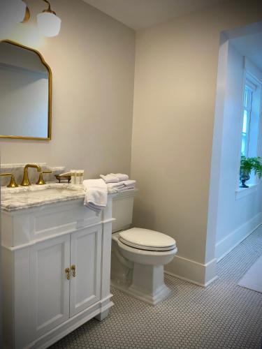 a bathroom with a toilet and a sink and a mirror at Old Village Inn Ogunquit in Ogunquit