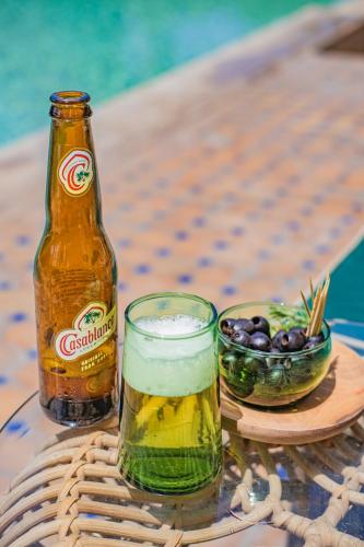 a bottle and a glass of beer and a bowl of olives at Villa Beldi in Essaouira