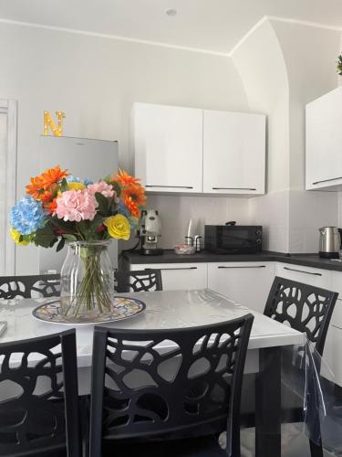 カターニアにあるNaomi Luxury Home 2の花瓶に花が飾られたテーブルのあるキッチン