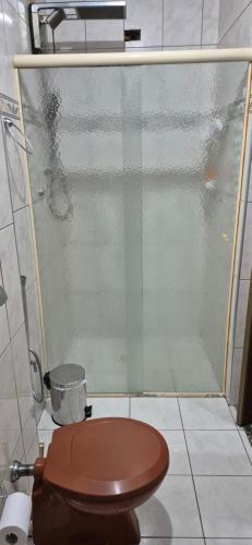 サン・ビセンテにあるApto 18 - Pé na areia, Santosのトイレとガラスのシャワー付きのバスルーム