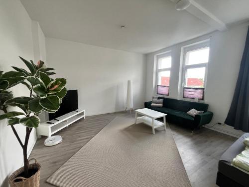 a living room with a couch and a potted plant at City Apartment in Magdeburg