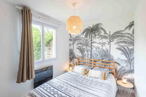 a bedroom with a bed with palm trees mural at Un havre de paix in Thonon-les-Bains