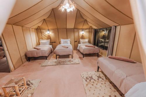 a room with four beds in a tent at Sultan's Sinbad Luxury Camp in Merzouga
