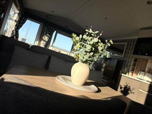 a vase sitting on top of a table with a plant at The Retreat Sea Breeze - Golden Sands Holiday Park in Kinmel Bay